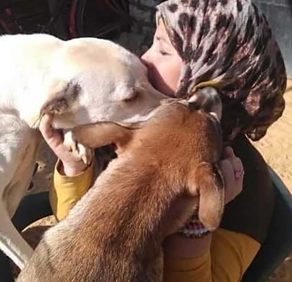 Animal rescuer, Hoda Mklad embracing her rescue dogs in Egypt.