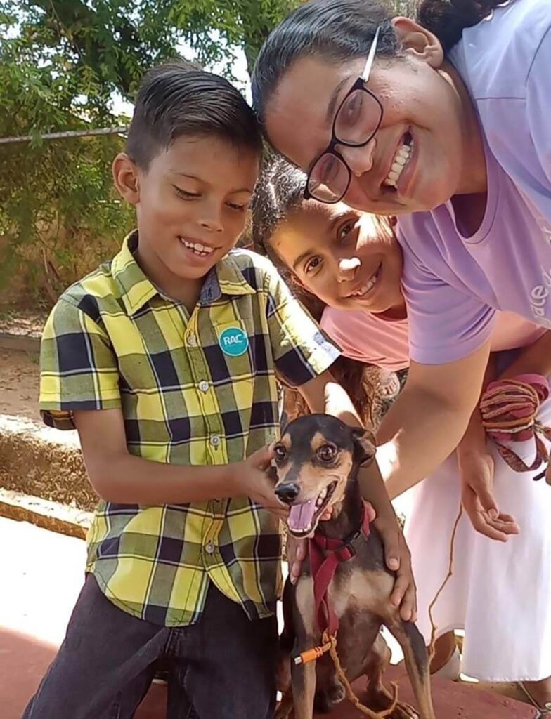 Children and rescue dog smiling in Venezuela